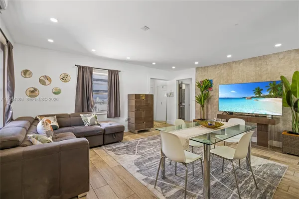 a living room with furniture kitchen view and a large window