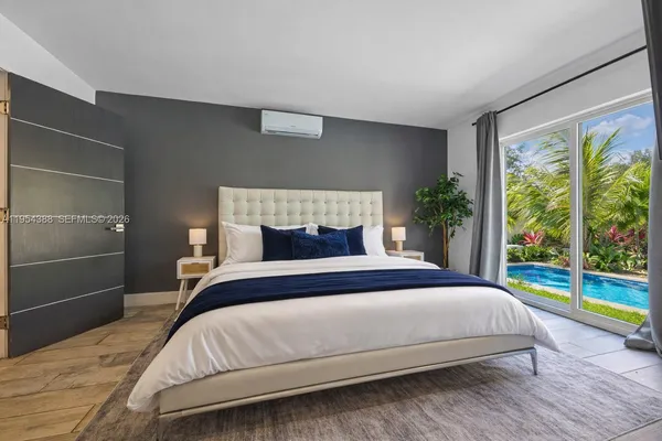 a bedroom with a bed and a large window