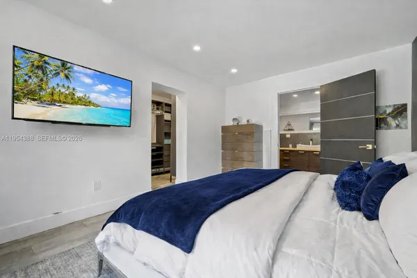 a bedroom with a large bed and a view of kitchen