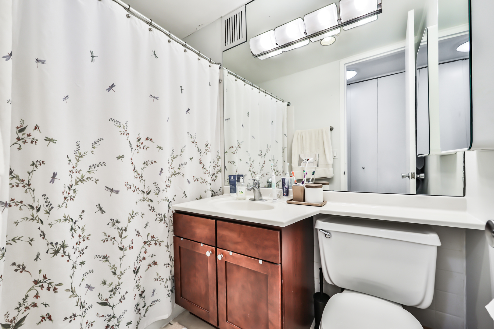 655 West Irving Park Road, Unit 3810 Chicago, IL 60613 - Photo 20 of 26 a bathroom with a sink a toilet and mirror