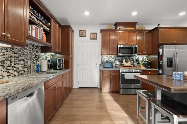 a kitchen with stainless steel appliances a stove a sink and a refrigerator