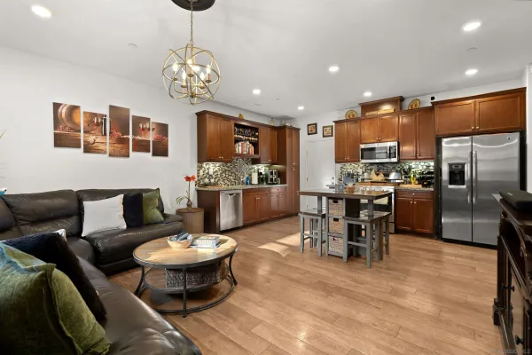 a living room with stainless steel appliances kitchen island a dining table and chairs