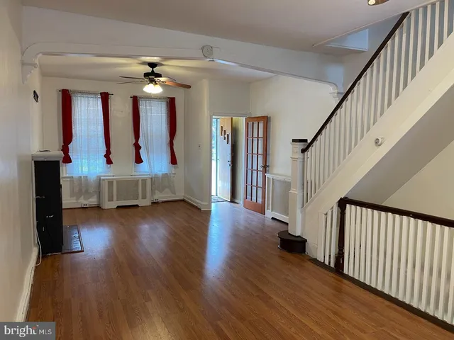 a view of a livingroom with wooden floor and furniture