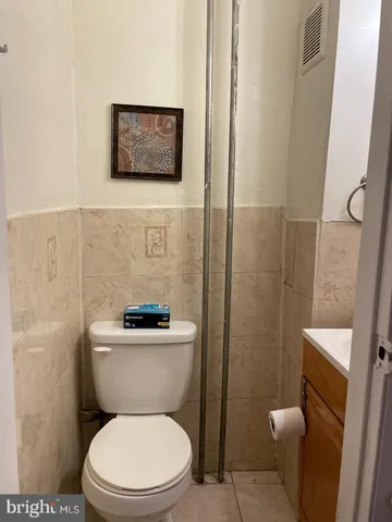 a white toilet sitting next to a bathroom sink and vanity