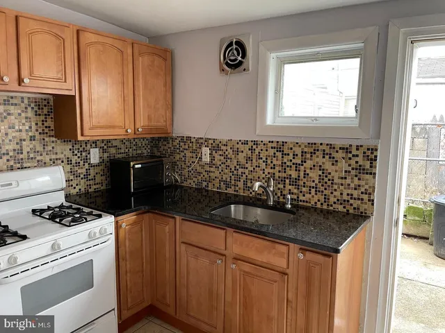 a kitchen with granite countertop a sink and a stove
