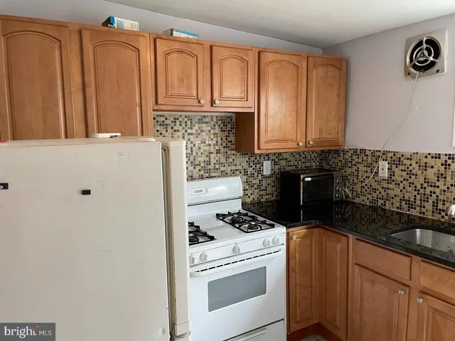 a kitchen with granite countertop cabinets and black appliances