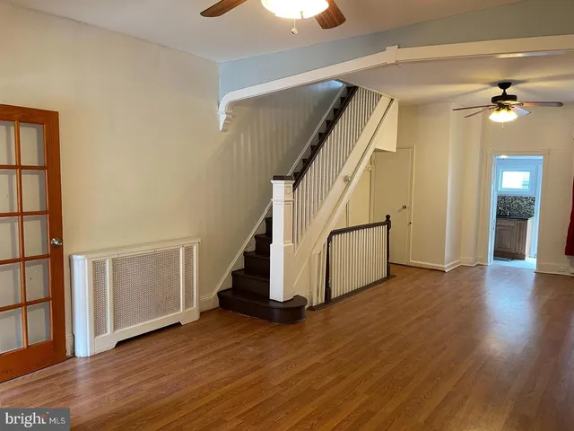 a view of a hallway with wooden floor and stairs