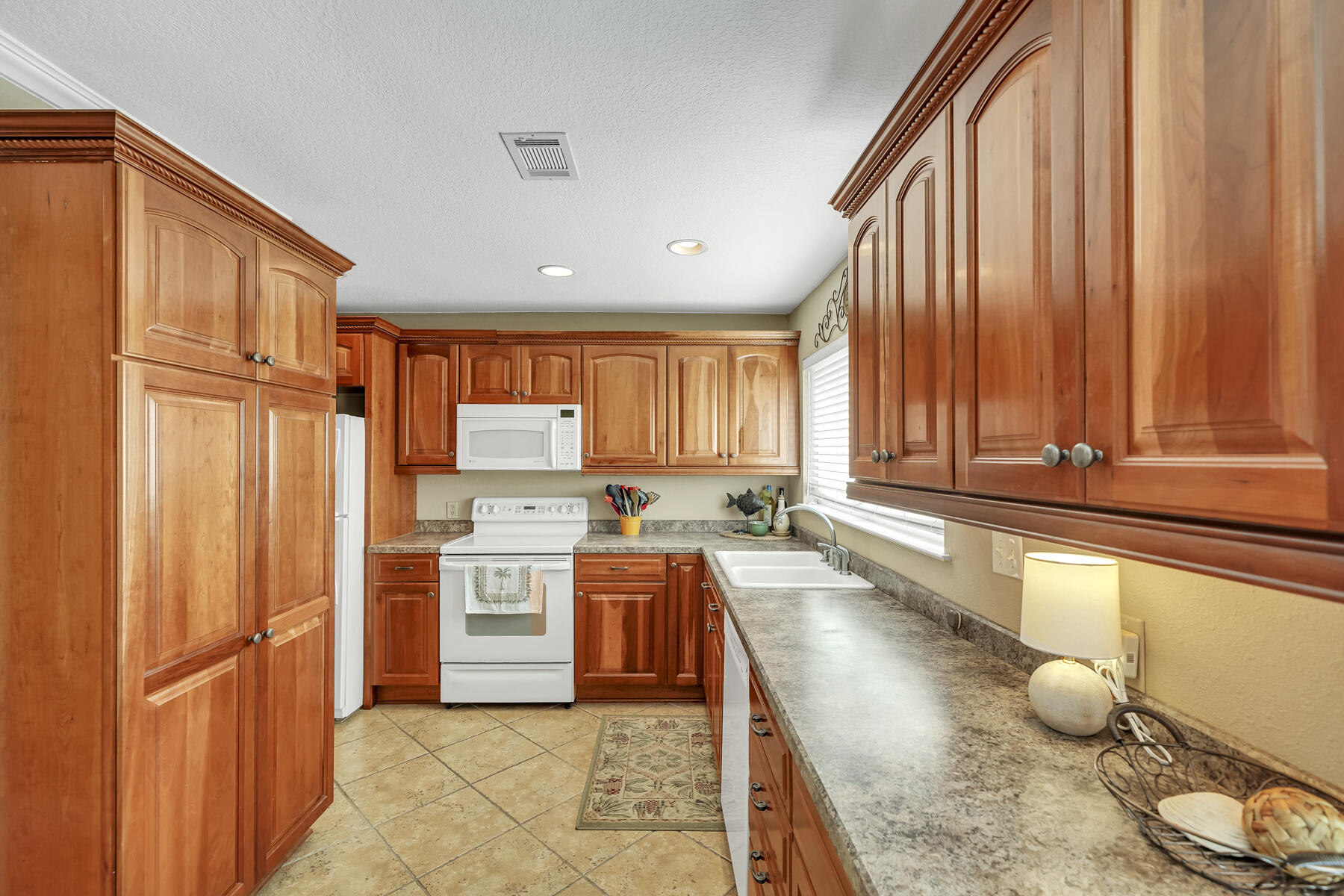 173 Durango Road Destin, FL 32541 - Photo 21 of 37 a large kitchen with stainless steel appliances granite countertop a refrigerator a sink dishwasher and wooden cabinets with wooden floor