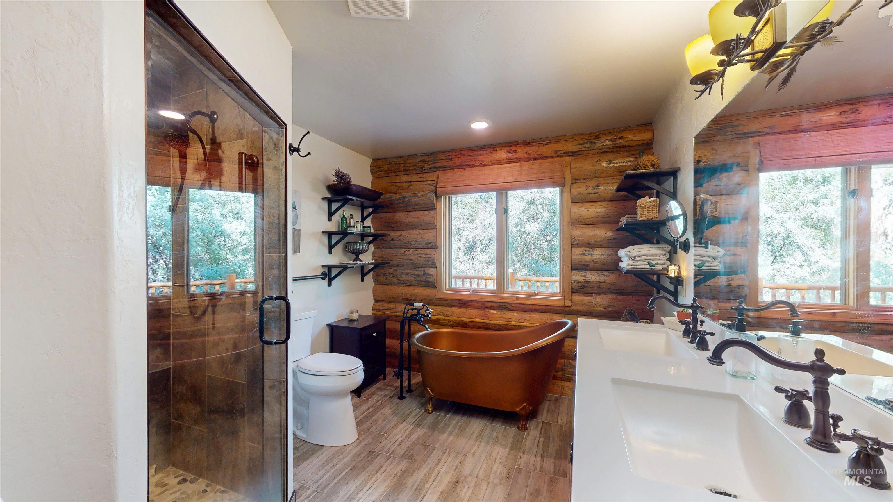 1314 River Road Buhl, ID 83316 - Photo 17 of 45 Full bath featuring rustic walls, plenty of natural light, a stall shower, a soaking tub, and double vanity