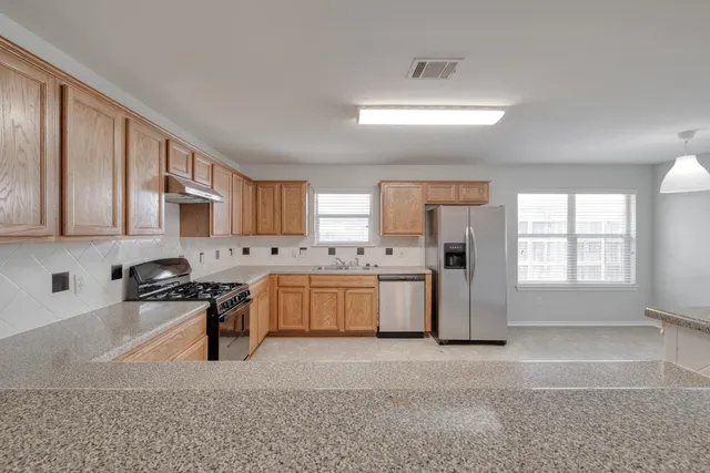 a kitchen with granite countertop cabinets stainless steel appliances and a sink