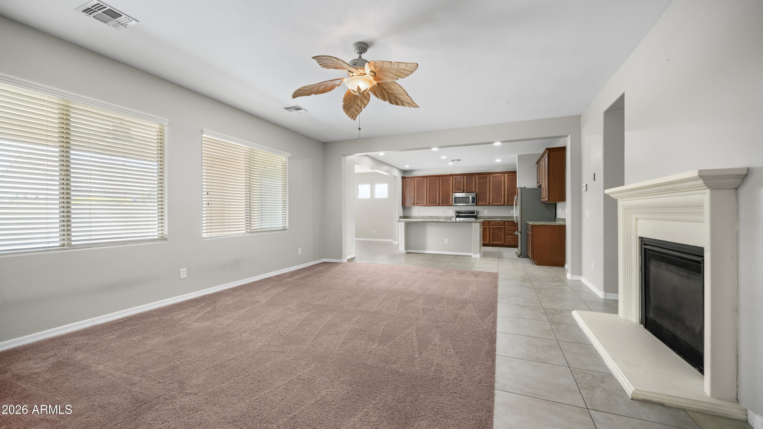 16159 West Granada Road Goodyear, AZ 85395 - Photo 9 of 41 a view of a livingroom with a fireplace a ceiling fan and windows