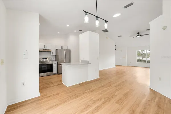 a view of a kitchen with kitchen island and stainless steel appliances