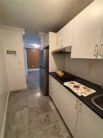 a kitchen with granite countertop a sink stove and cabinets