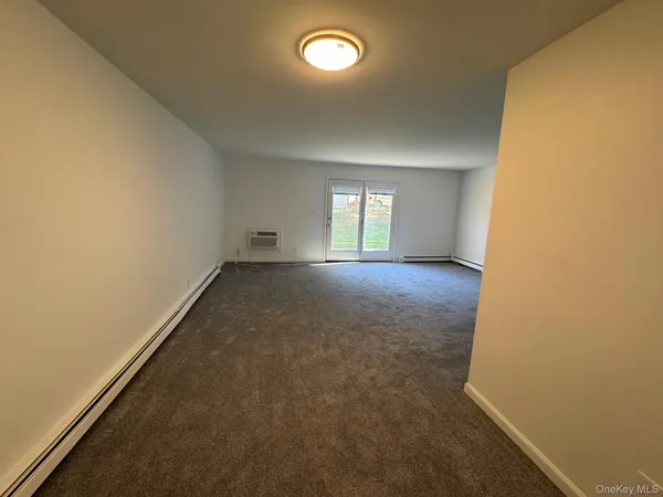 an empty room with a fireplace and windows