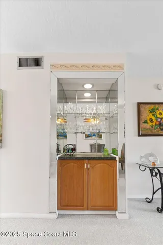 a room with stainless steel appliances wooden floor and view kitchen