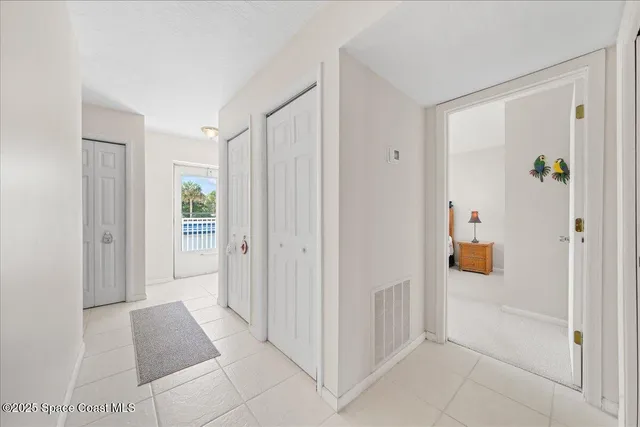 a view of a hallway with closet and a bathroom