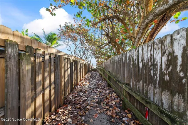 a view of a pathway of a building with wooden fence