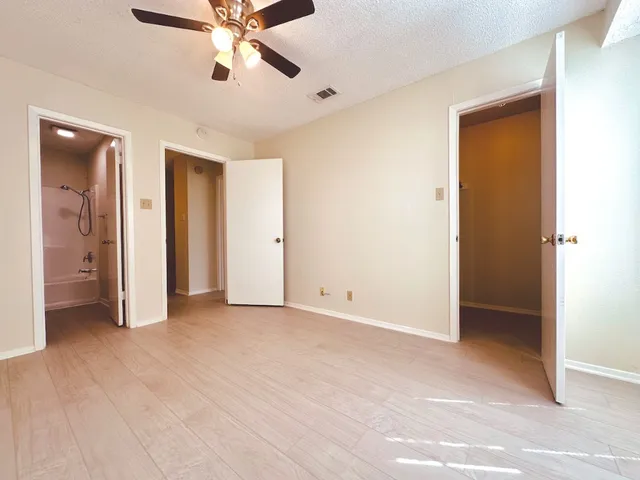 a view of an empty room with a ceiling fan