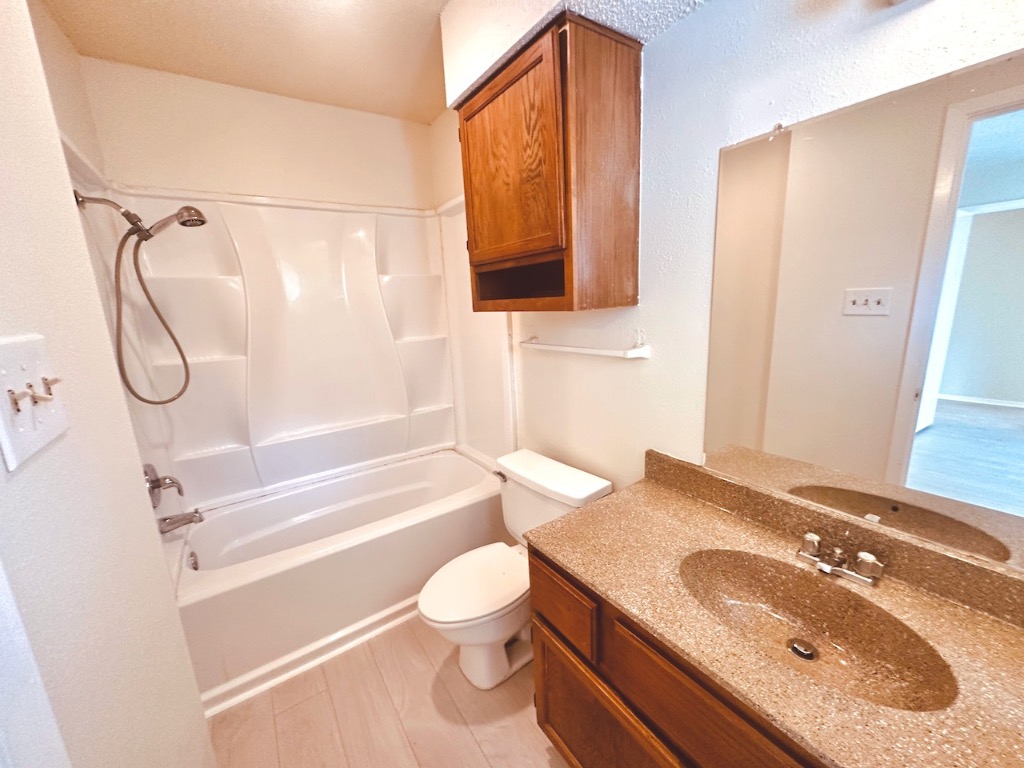2004 Kirksey Drive, Unit D Austin, TX 78741 - Photo 17 of 20 a bathroom with a granite countertop sink toilet and shower