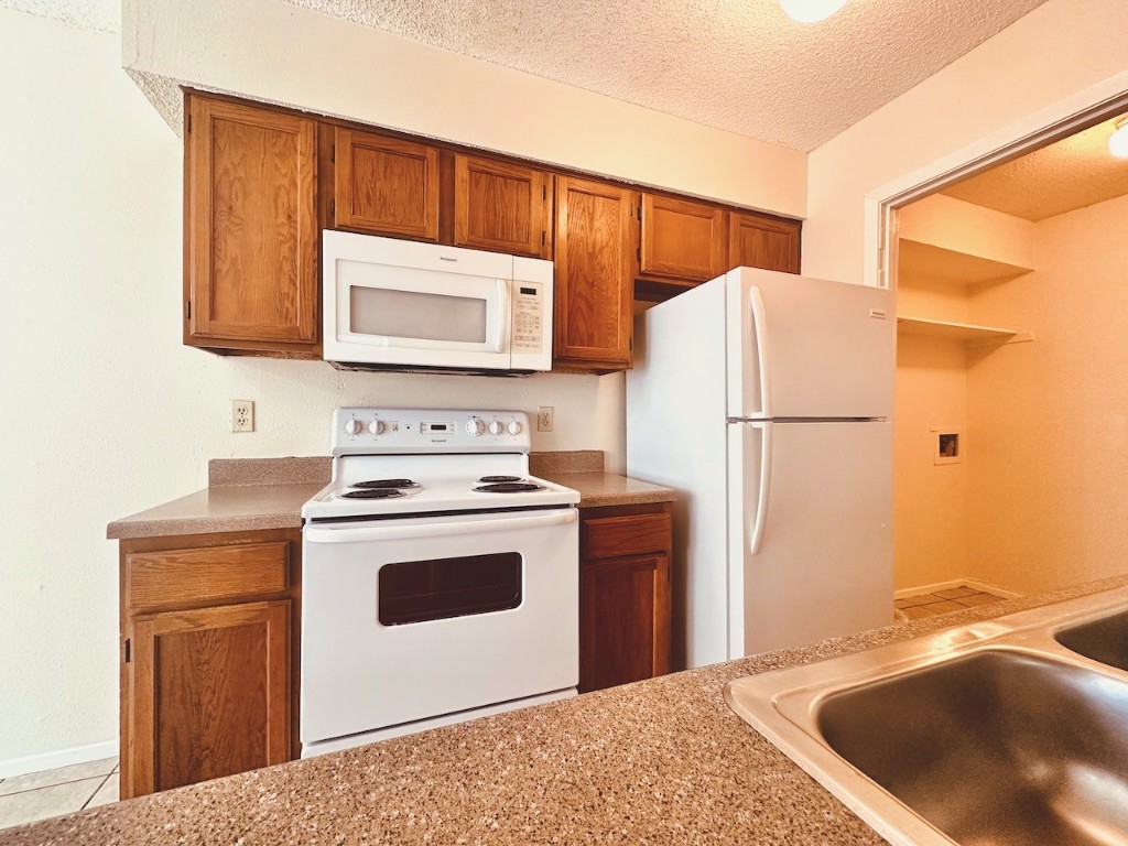 2004 Kirksey Drive, Unit D Austin, TX 78741 - Photo 5 of 20 a kitchen with a sink a stove and a refrigerator