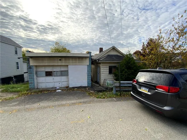 a backyard of a house with barbeque oven and a table and chairs