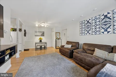 a living room with furniture and a dining table with kitchen view
