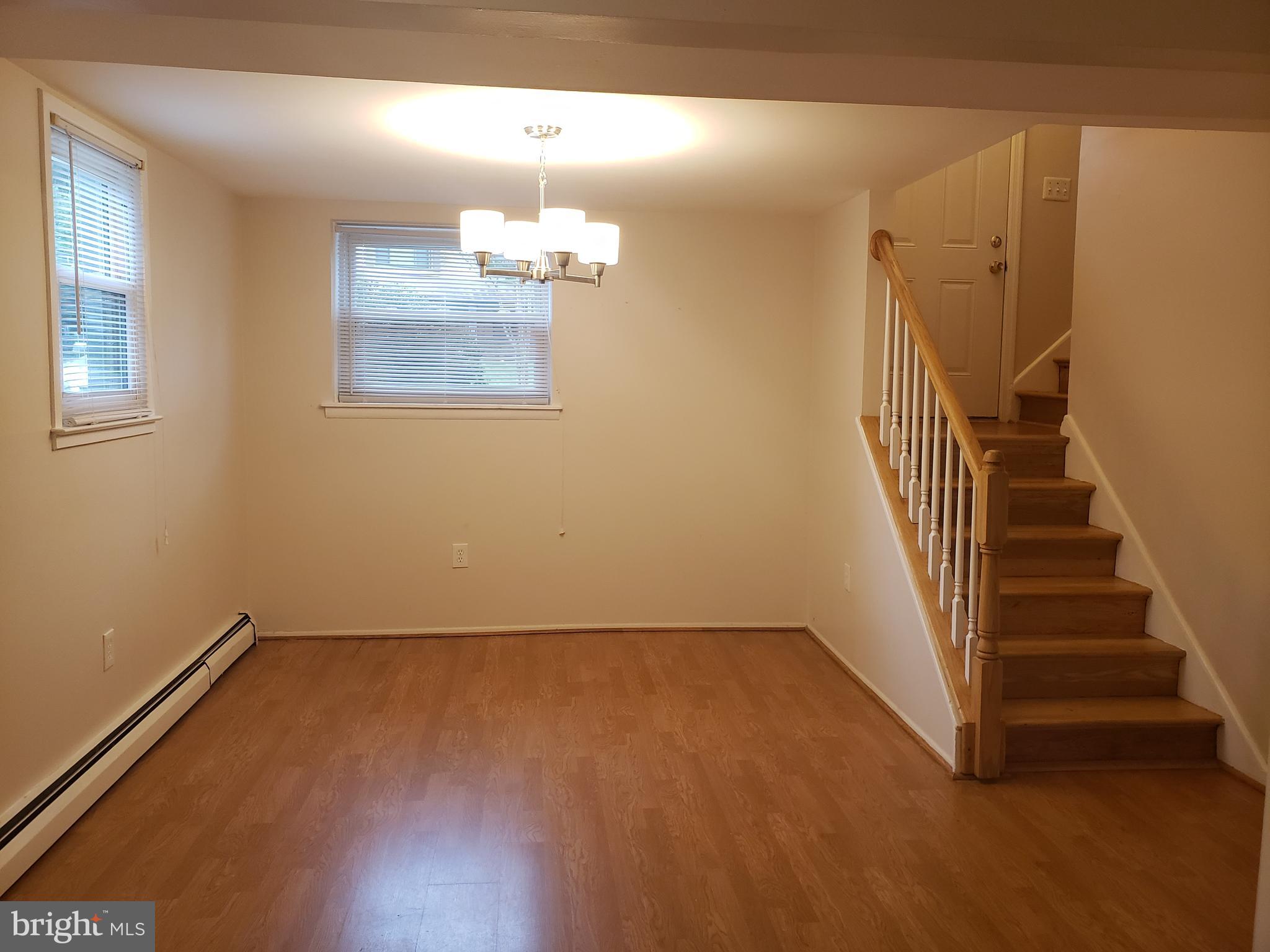 13350 Kerrydale Road Woodbridge, VA 22193 - Photo 4 of 10 an empty room with wooden floor and staircase