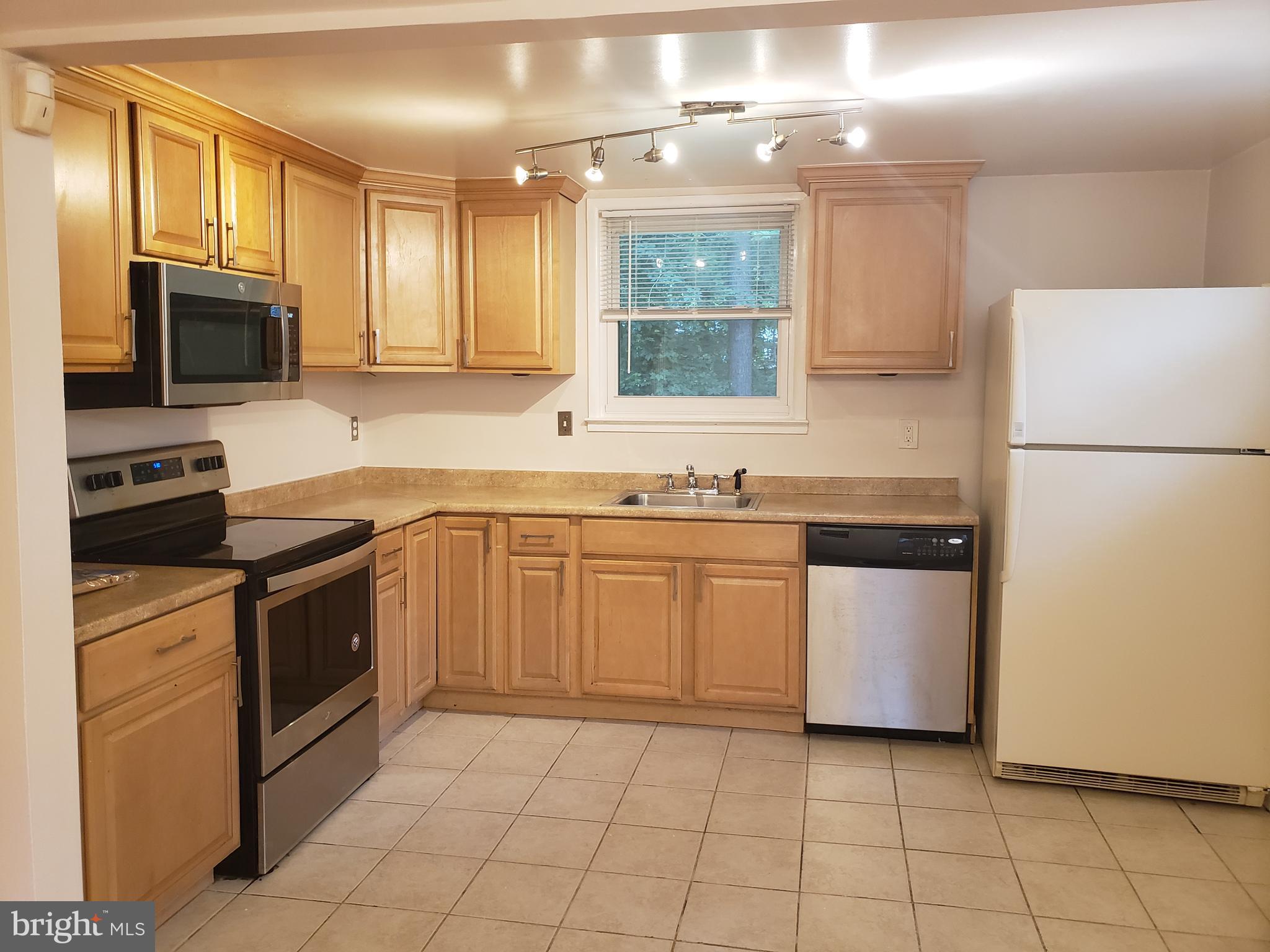 13350 Kerrydale Road Woodbridge, VA 22193 - Photo 5 of 10 a kitchen with a sink a stove top oven and white stainless steel appliances