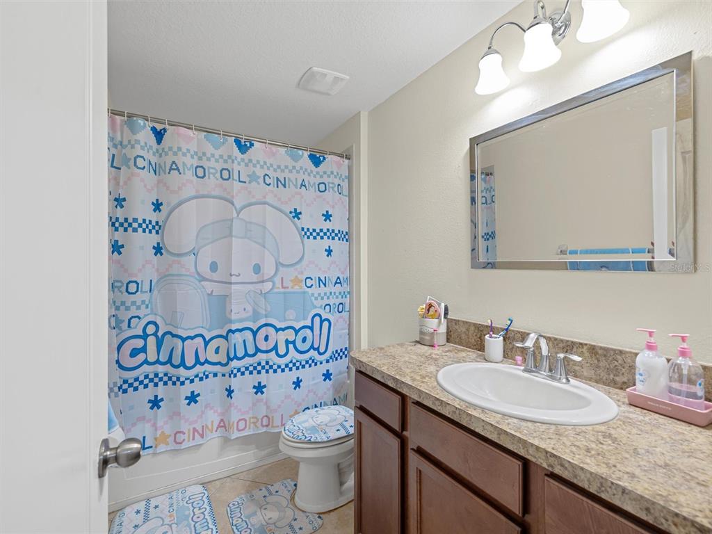 9588 Trumpet Vine Loop Trinity, FL 34655 - Photo 27 of 49 a bathroom with a granite countertop toilet sink mirror and shower