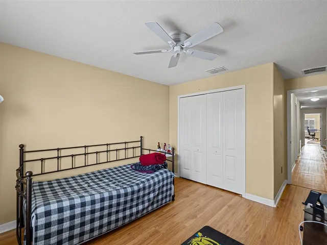 a bedroom with a bed and wooden floor
