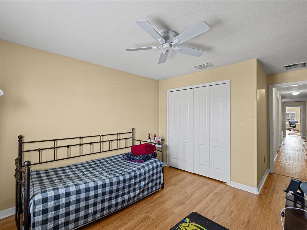 9588 Trumpet Vine Loop Trinity, FL 34655 - Photo 30 of 49 a bedroom with a bed and wooden floor