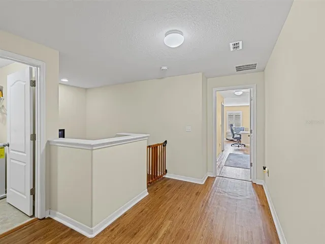 a view of a hallway with wooden floor and staircase
