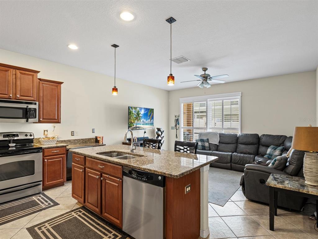 9588 Trumpet Vine Loop Trinity, FL 34655 - Photo 6 of 49 a kitchen with stainless steel appliances granite countertop a sink stove and cabinets
