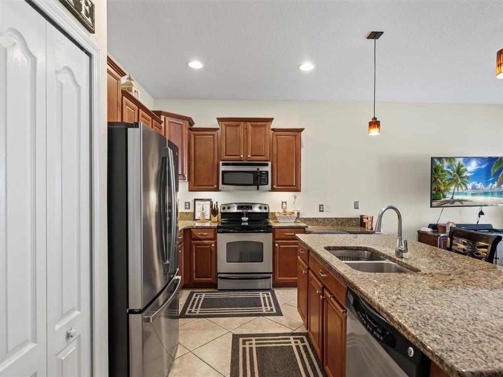 9588 Trumpet Vine Loop Trinity, FL 34655 - Photo 7 of 49 a kitchen with stainless steel appliances granite countertop a sink stove and refrigerator