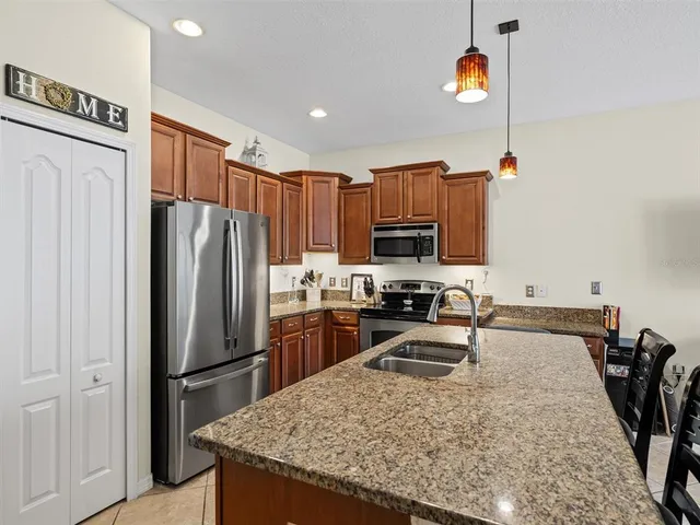 a kitchen with stainless steel appliances granite countertop a refrigerator a stove top oven a sink and dishwasher