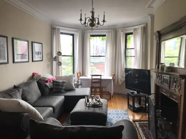 a living room with furniture a flat screen tv and a large window