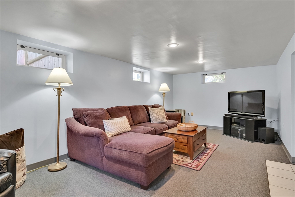 90 Governors Road Milton, MA 02186 - Photo 18 of 28 a living room with furniture a lamp and a flat screen tv