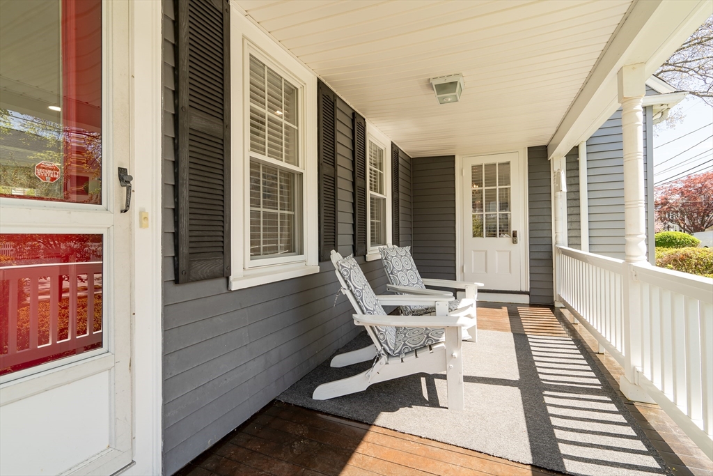 90 Governors Road Milton, MA 02186 - Photo 3 of 28 a balcony with wooden benches and glass windows