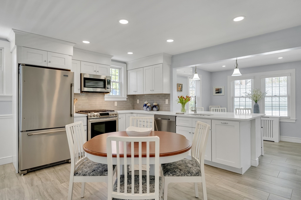 90 Governors Road Milton, MA 02186 - Photo 5 of 28 a kitchen with stainless steel appliances granite countertop a refrigerator a stove a sink a dining table and chairs