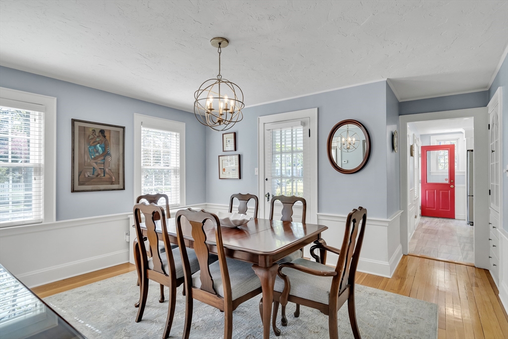 90 Governors Road Milton, MA 02186 - Photo 8 of 28 a view of a dining room with furniture a chandelier and wooden floor