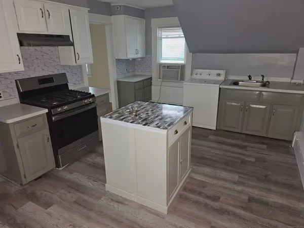a kitchen with a sink stove and cabinets