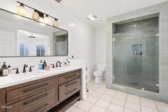 a bathroom with a double vanity sink mirror and shower