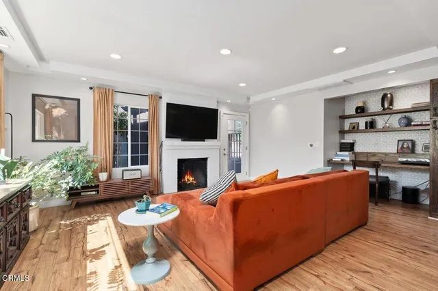 a living room with furniture a flat screen tv and a fireplace