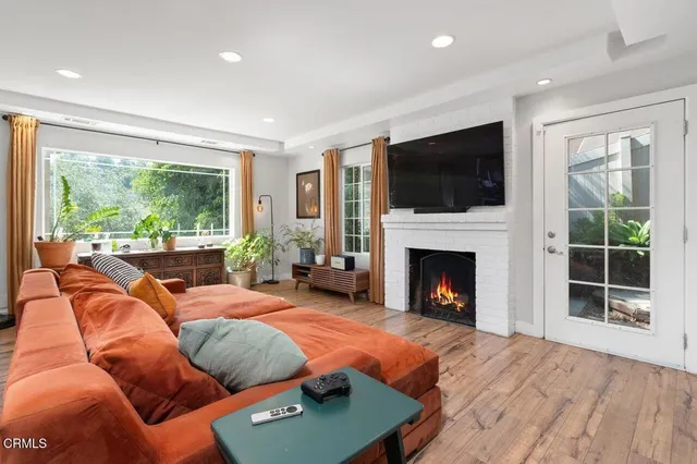 a outdoor living space with furniture a fireplace and a flat screen tv