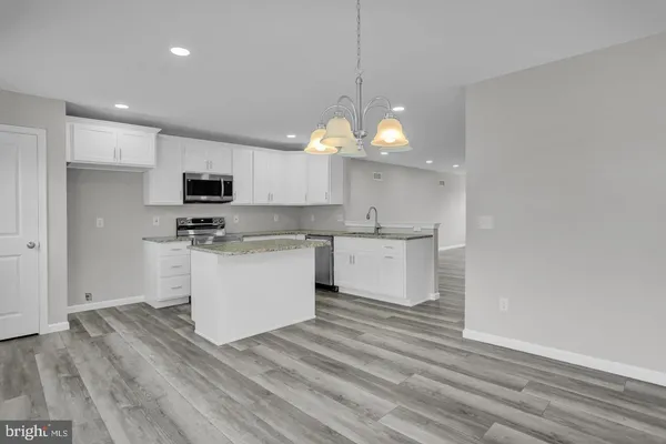 a view of kitchen with microwave stove refrigerator and cabinets