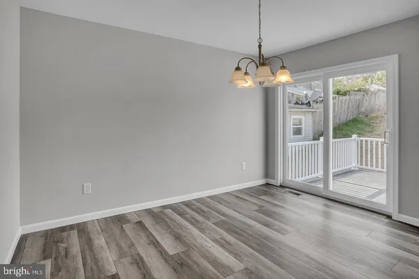 a view of a room with wooden floor a ceiling fan and window