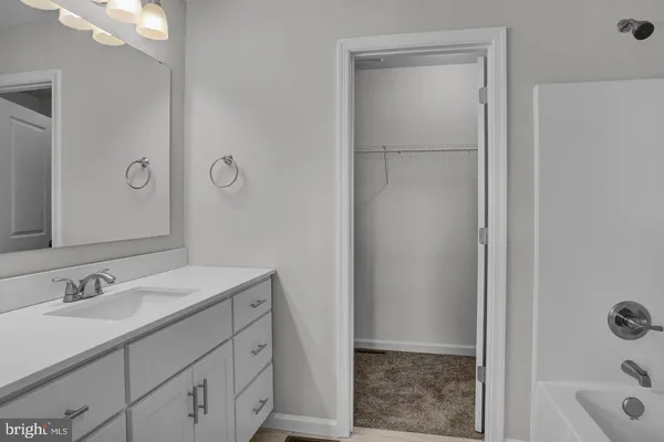 a bathroom with a granite countertop sink a mirror and a shower