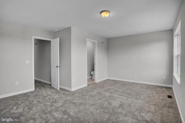 an empty room with closet and a window
