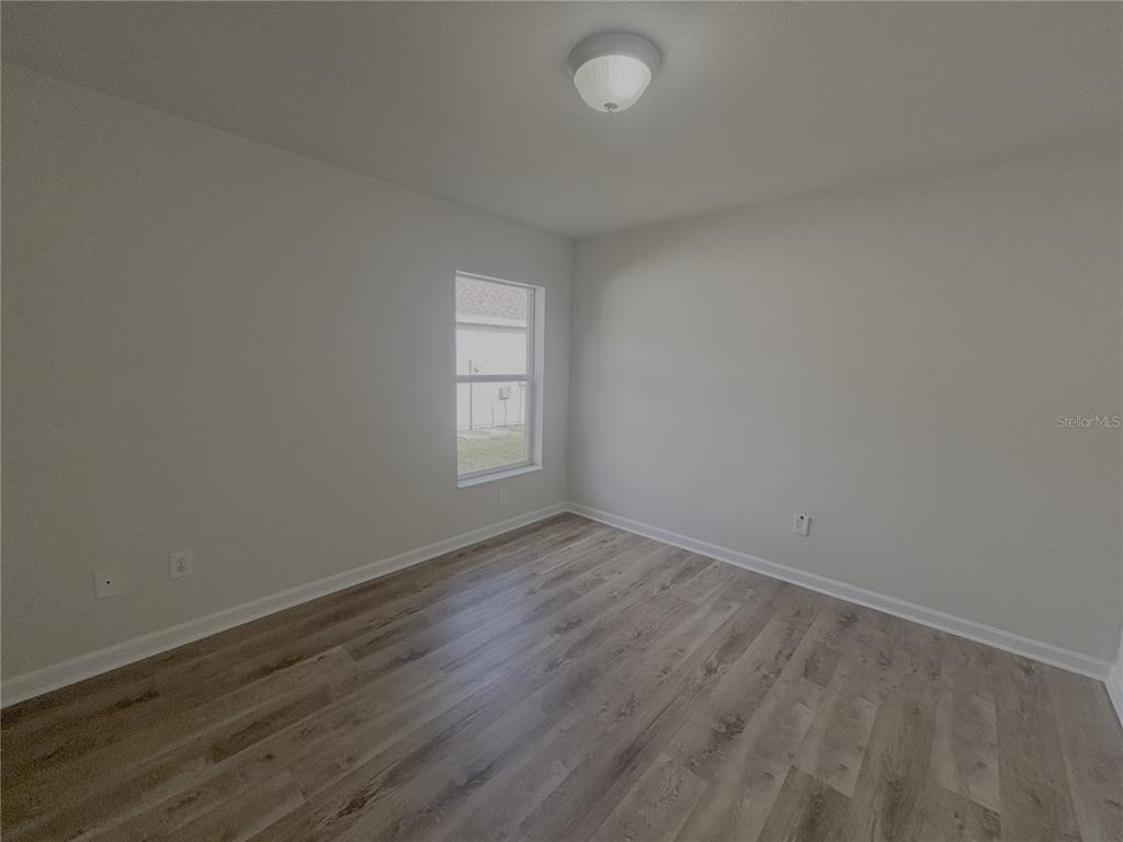 4194 Southwest 47th Court Ocala, FL 34474 - Photo 16 of 29 an empty room with wooden floor and windows