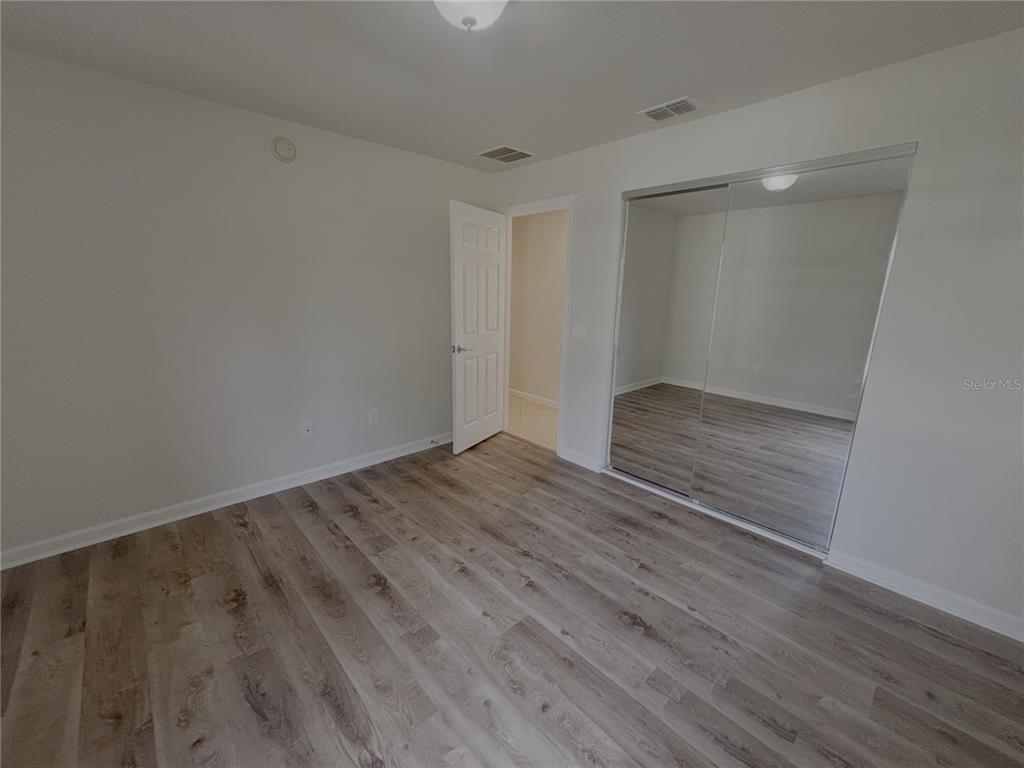4194 Southwest 47th Court Ocala, FL 34474 - Photo 17 of 29 a view of an empty room with wooden floor and a window